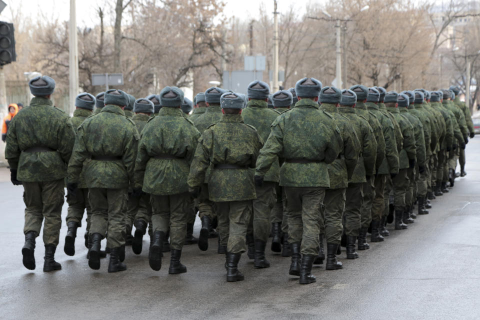 Servicemen march leaving a memorial ceremony to honor the memory of civilians who died during shelling at a crowded bus stop in 2015, in Donetsk, controlled by Russia-backed separatists, eastern Ukraine, Saturday, Jan. 22, 2022. (AP Photo/Alexei Alexandrov)