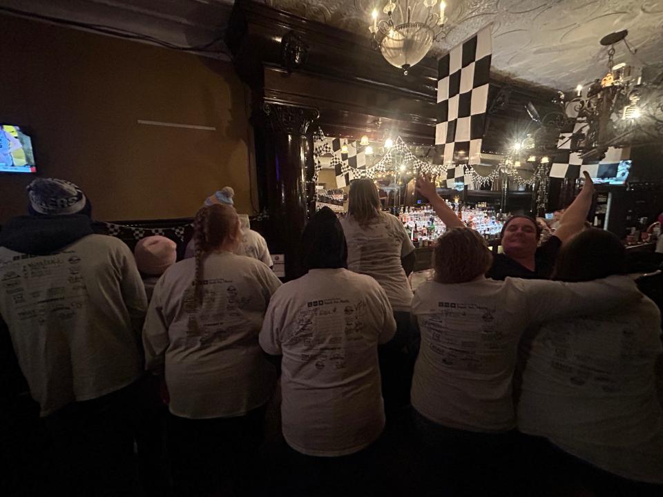 Several I-500 pub crawlers show off the collection of shirt signatures they've collected from various downtown bars on Thursday, Feb. 2, 2023.