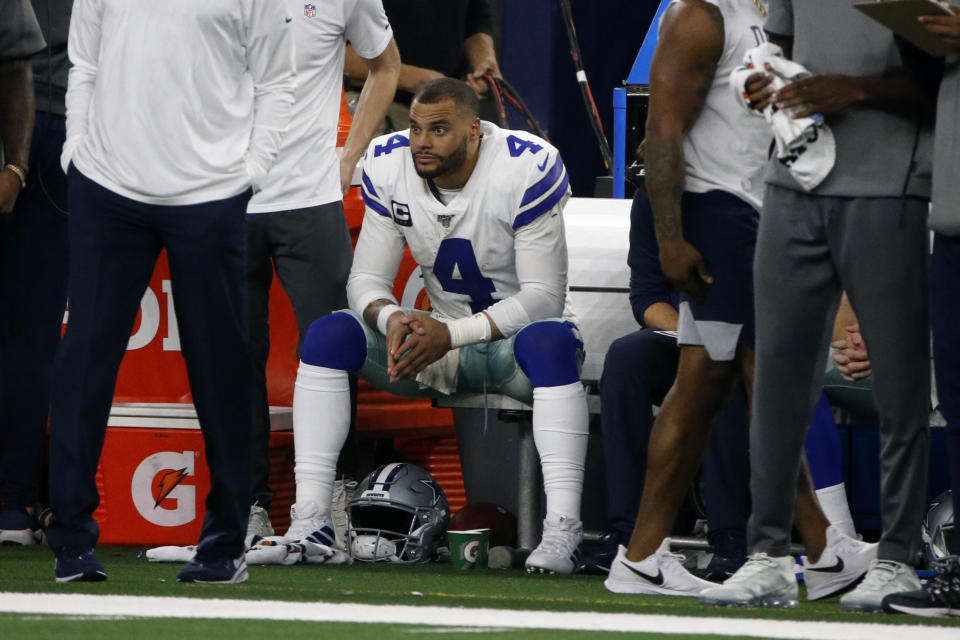 Dallas Cowboys quarterback Dak Prescott (4) sits on the bench by staff late in the second half of an NFL football game against the Buffalo Bills in Arlington, Texas, Thursday, Nov. 28, 2019. (AP Photo/Michael Ainsworth)