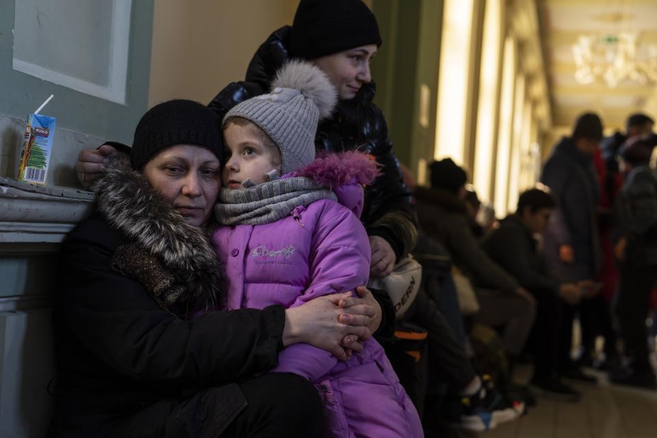 Ukrainian refugee Elena, left, hugs her five-year old granddaughter Christina, as they wait the train to Warsaw, at the Przemysl train station, southeastern Poland, on Friday, March 11, 2022. (AP Photo/Petros Giannakouris)