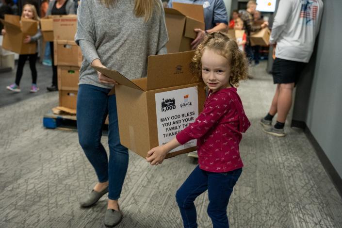 Volunteers spanned the generations as Emily Olinger packs boxes at the Feed the 5,000 packing party held at Grace Baptist Church Wednesday Nov. 17, 2021.