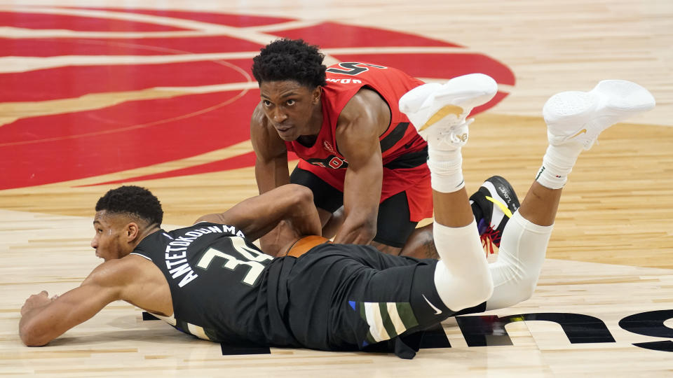 Milwaukee Bucks forward Giannis Antetokounmpo (34) fouls Toronto Raptors forward Stanley Johnson (5) as they battle for the ball during the second half of an NBA basketball game Wednesday, Jan. 27, 2021, in Tampa, Fla. (AP Photo/Chris O'Meara)