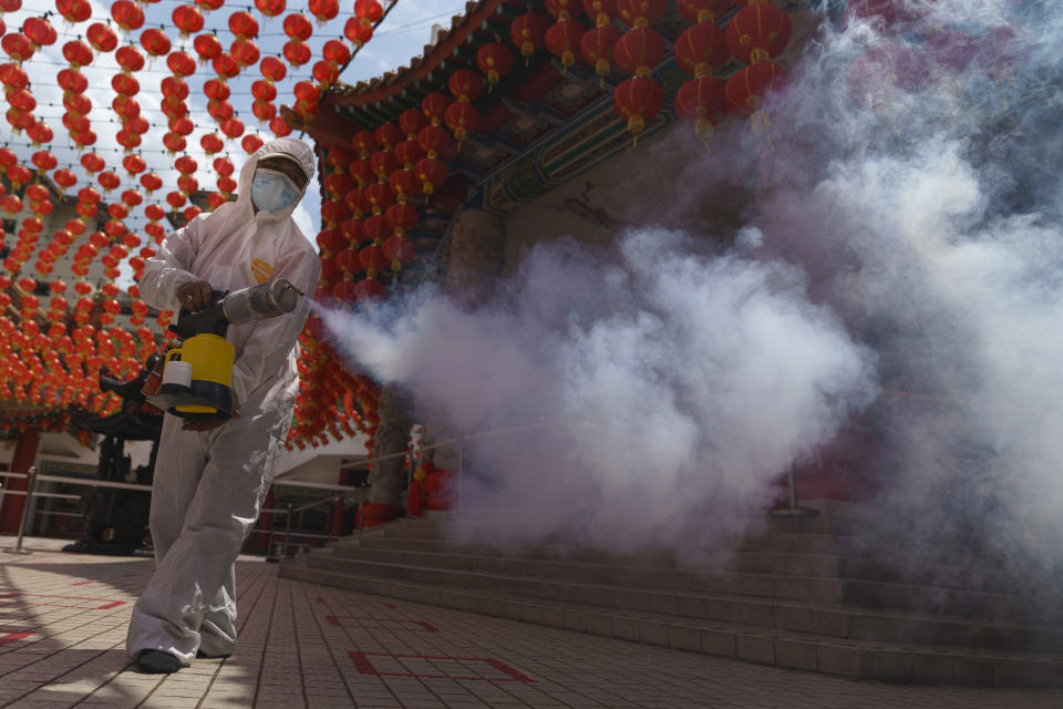 A worker disinfects the Thean Hou Temple during during first day of Chinese Lunar New Year celebrations in Kuala Lumpur, Friday, Feb. 12, 2021. The movement control order (MCO) currently enforced across the country to help curb the spread of the coronavirus, has been extended to Feb. 18, effectively covering the Chinese New Year festival that falls on Feb. 12 this year. (AP Photo/Vincent Thian)