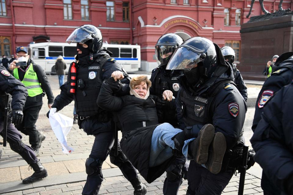 Police officers detain a woman during a protest against Russian military action in Ukraine, in Manezhnaya Square in central Moscow on March 13, 2022.