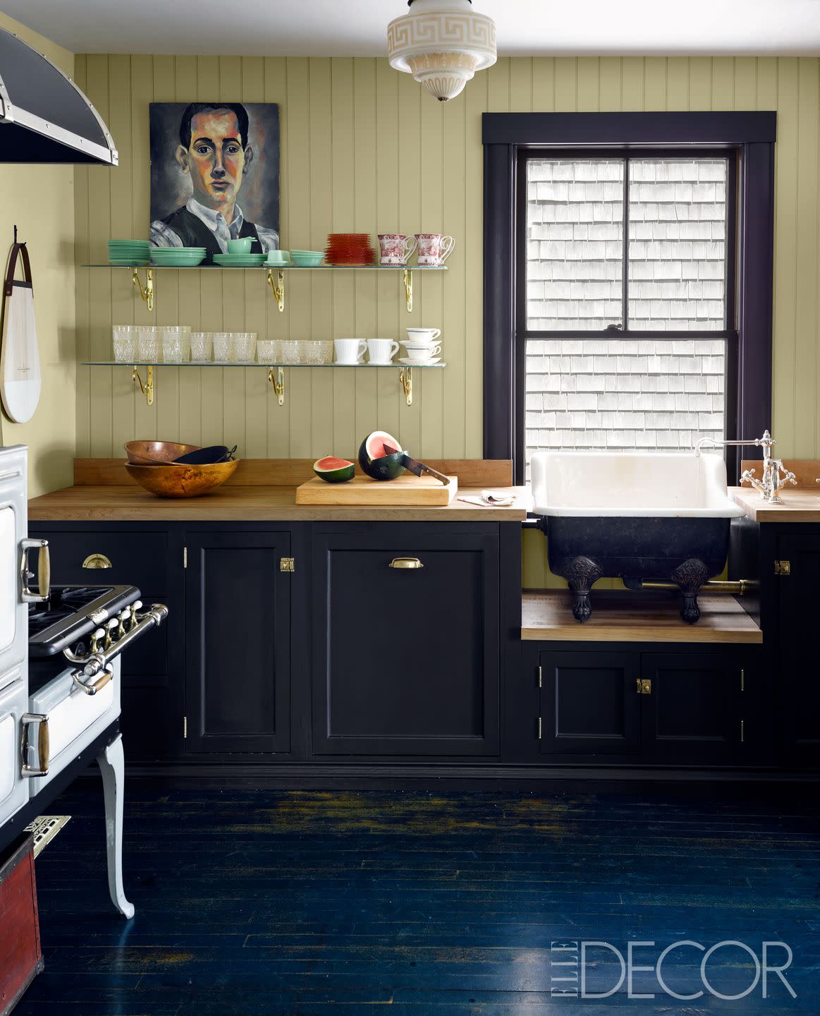 the custom made cabinetry is painted in tanner's brown, and the walls are in cream, both by farrow the countertops are butcher block, the sink fittings are by waterworks, and the wedgewood stove is antique