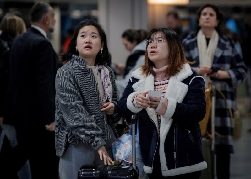 Travelers wait for information to board trains during the Thanksgiving holiday travel rush at Pennsylvania Station in New York