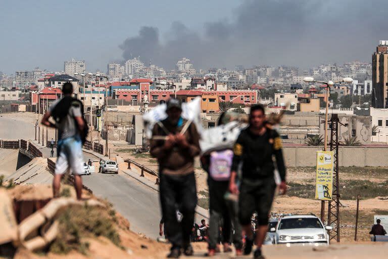 El humo se eleva sobre los edificios durante el bombardeo israelí mientras las personas que huyen del complejo hospitalario de Al-Shifa y sus alrededores en la ciudad de Gaza llegan a la parte central de la Franja de Gaza el 21 de marzo de 2024.