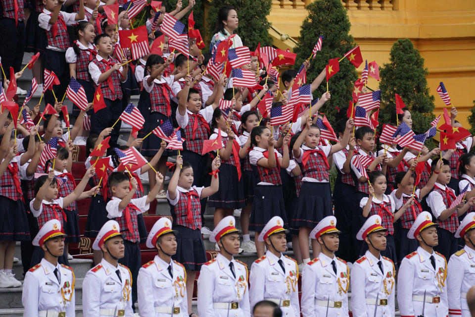 Children wave flags of both countries as U.S. President Joe Biden participates in a welcome ceremony hosted by Vietnam's Communist Party General Secretary Nguyen Phu Trong at the Presidential Palace in Hanoi, Vietnam, Sunday, Sept. 10, 2023. (AP Photo/Evan Vucci)