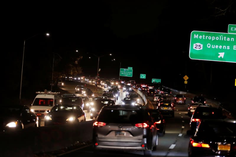 Lights illuminate the roadway as cars sit in traffic to depart New York City the day before the Thanksgiving holiday in New York