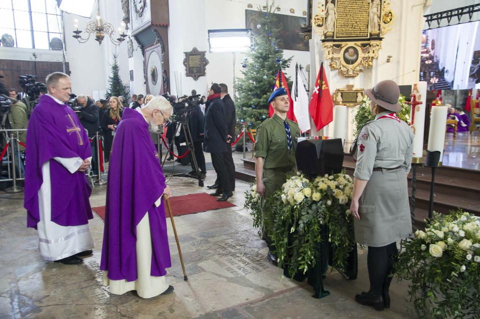 Catholic priests bowing with respect before the urn with ashes of slain Gdansk city Mayor Pawel Adamowicz at the start of his funeral Mass attended by Poland's and European officials, in Gdansk, Poland, on Saturday, Jan. 19, 2019. Adamowicz died Monday after being stabbed the night before at a charity event by an ex-convict with a grudge against an opposition party that Adamowicz once belonged to.(AP Photo/Wojtek Strozyk)