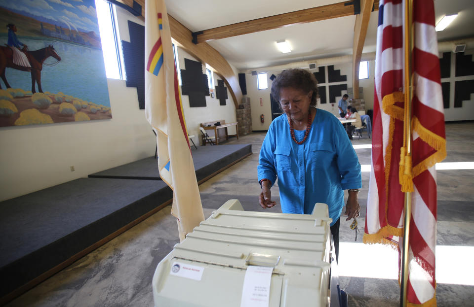 FILE - In this July 21, 2015 file photo, Martha Johnson turns in her ballot at the Nenahnezad Chapter House in Fruitland, N.M., during the Navajo Nation's referendum election to decide the language qualifications for future leaders. The U.S. Supreme Court disagreed on Thursday, July 1, 2021, in a broader case over Arizona voting regulations, upholding a prohibition on counting ballots cast in the wrong precinct and returning early ballots for another person. The ruling will reach broadly into tribal communities, particularly those where Indigenous people don't have residential mail service or must drive long distances to polling sites and the post office. (Jon Austria/The Daily Times via AP, File)