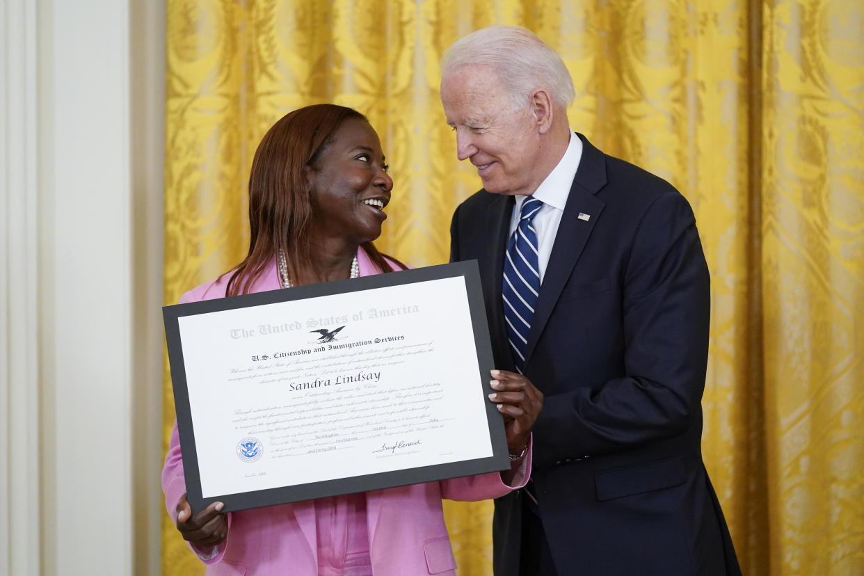 FILE - President Joe Biden recognizes Sandra Lindsay as an "Outstanding American by Choice," a U.S. Citizenship and Immigration Services program that recognizes citizens who have been naturalized in the East Room of the White House, Friday, July 2, 2021, in Washington. Lindsay is believed to be the first American to be vaccinated against COVID-19 outside of a clinical trial. She works as director of nursing for critical care at Northwell Health's Long Island Jewish Medical Center in Queens, New York. (AP Photo/Patrick Semansky, File)