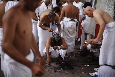 A Muslim pilgrim has his head shaved after casting pebbles at a pillar that symbolizes Satan during the annual haj pilgrimage, on the first day of Eid al-Adha in Mina, near the holy city of Mecca October 15, 2013. REUTERS/Ibraheem Abu Mustafa