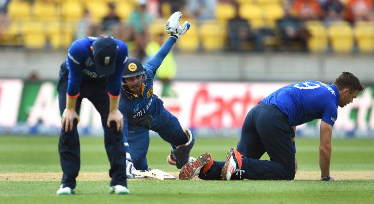 Sri Lanka's batsman Kumar Sangakkara (C) survives a run-out chance against England during their World Cup Pool A match in Wellington, on March 1, 2015