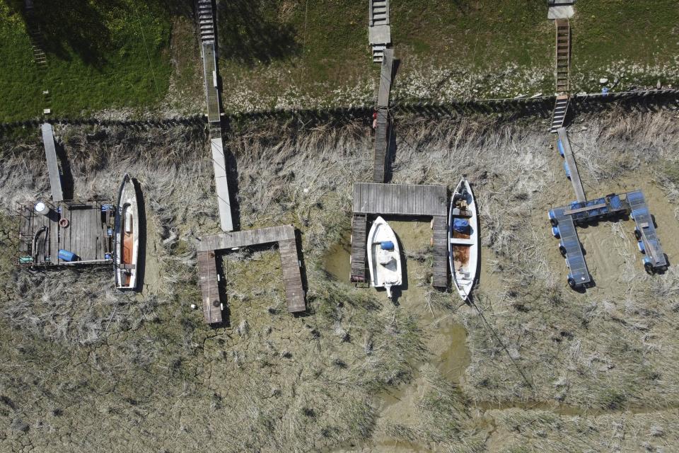 Boats lie on the dried shipyard on the Po River in Torricella, near Cremona, Italy, Wednesday, April 19, 2023. Italy's largest river is already as low as it was last summer, sparking fears of precariously dry months ahead. (AP Photo/Luca Bruno)