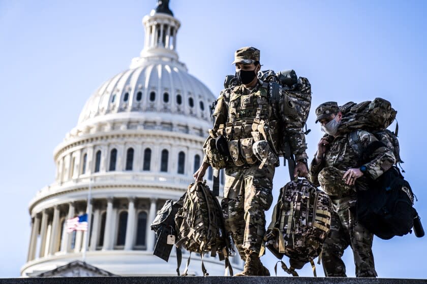 WASHINGTON, DC - JANUARY 14: Members of the National Guard, outside the U.S. Capitol Building - a day after the House of Representatives impeached President Donald Trump, and over a week after a pro-Trump insurrectionist mob breached the security of the nation's capitol - on Thursday, Jan. 14, 2021 in Washington, DC. An estimated 20,000 National Guard troops are expected to be deployed to the city to support law enforcement - around three times the total number of American troops deployed abroad in Iraq, Afghanistan, Somalia and Syria. (Kent Nishimura / Los Angeles Times)