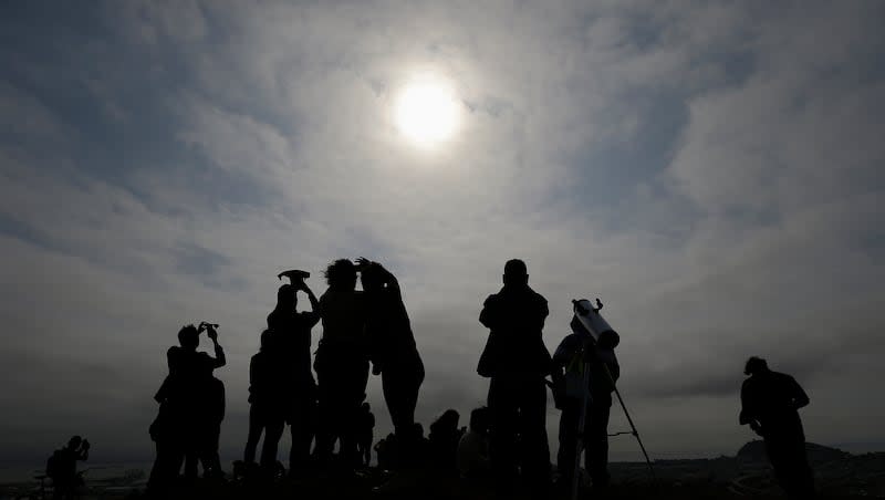 A crowd watches the solar eclipse from Bernal Heights Hill in San Francisco, Monday, Aug. 21, 2017.