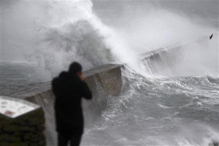 Waves crash over the breakwater of Saint Evette harbour at Esquibien in Brittany as an Atlantic storm hits western France, December 23, 2013. REUTERS/Mal Langsdon