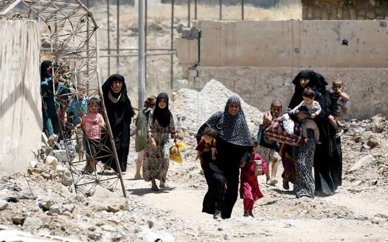 Displaced civilians walk towards the Iraqi Army positions after fleeing their homes due to clashes in the Shifa neighbourhood in western Mosul, Iraq June 15, 2017. REUTERS/Erik De Castro