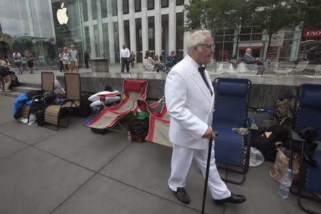 A man, dressed up as Colonel Sanders, walks outside the Apple Store in advance of an Apple special event, in the Manhattan borough of New York September 9, 2014. REUTERS/Carlo Allegri