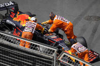 Track marshalls push the car of Red Bull driver Max Verstappen of the Netherlands after it hit a wall during the third free practice session at the Baku Formula One city circuit in Baku, Azerbaijan, Saturday, June 5, 2021. The Azerbaijan Formula One Grand Prix will take place on Sunday. (AP Photo/Darko Vojinovic)