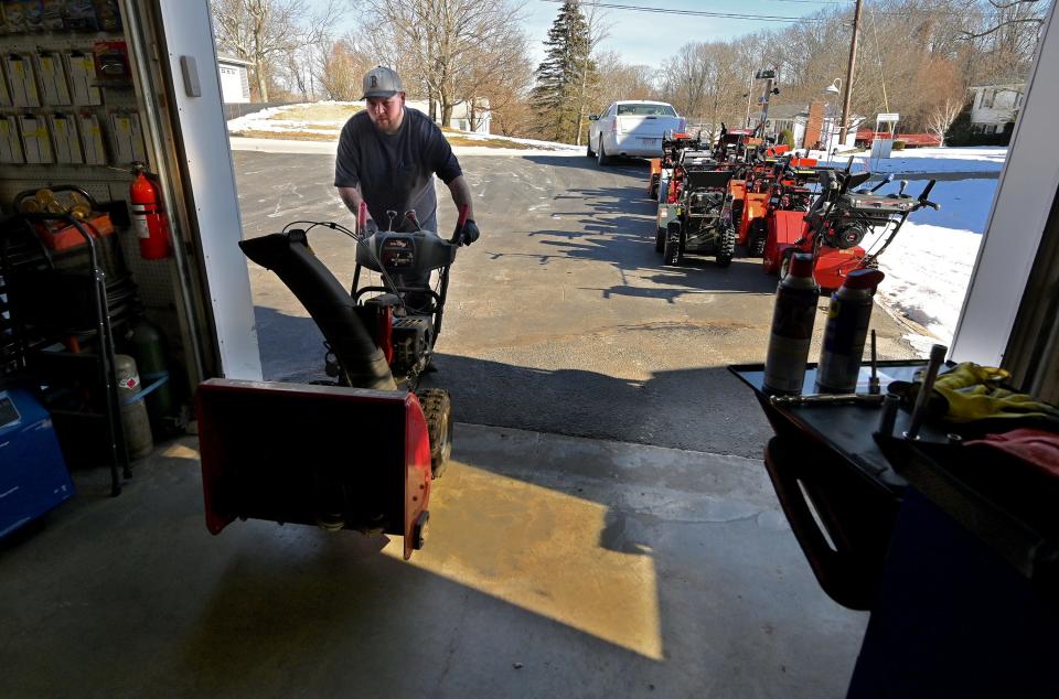 MILLBURY - At Alexander's Small Engine Repair, Mark Lizotte brings in the next snowblower as he and his uncle Dave Alexander work a brisk pace to get their repair orders done before Saturday's snow storm.