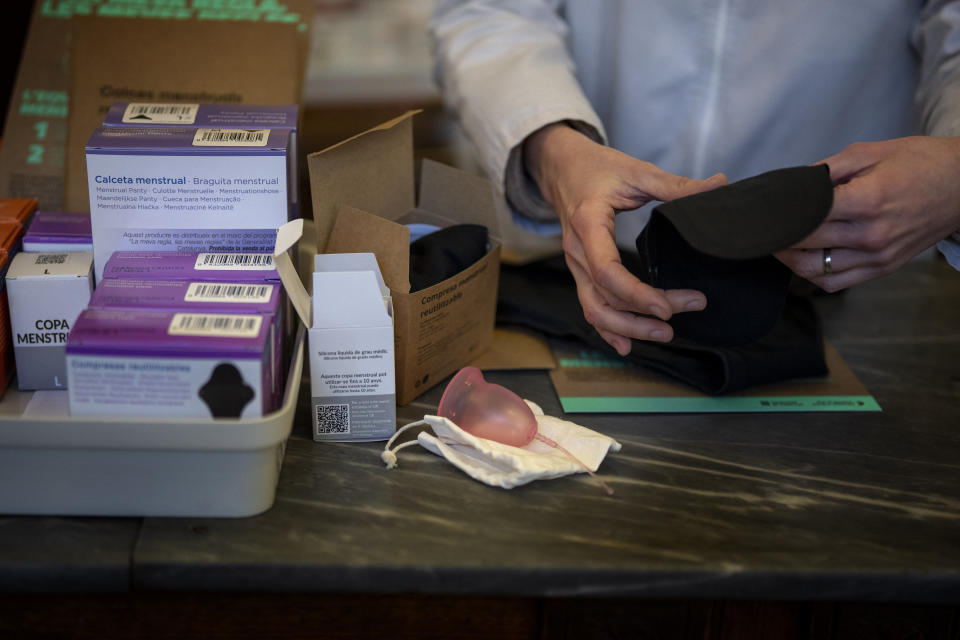 A pharmacist prepares an underwear for periods next to other items free of charge, at a pharmacy in Barcelona, Spain, Tuesday, March 5, 2024. Spain's Catalonia region rolled out this week a pioneering women's health initiative that offers millions of women reusable menstruation products for free. Some 2.5 million women in northeast Spain can receive one menstrual cup, one pair of underwear for periods, and two packages of cloth pads at local pharmacies free of charge. (AP Photo/Emilio Morenatti)