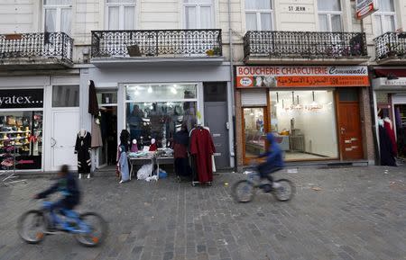 Boys ride on their bicycles past shops in the neighbourhood of Molenbeek, where Belgian police staged a raid following the attacks in Paris, at Brussels, Belgium November 15, 2015. REUTERS/Yves Herman