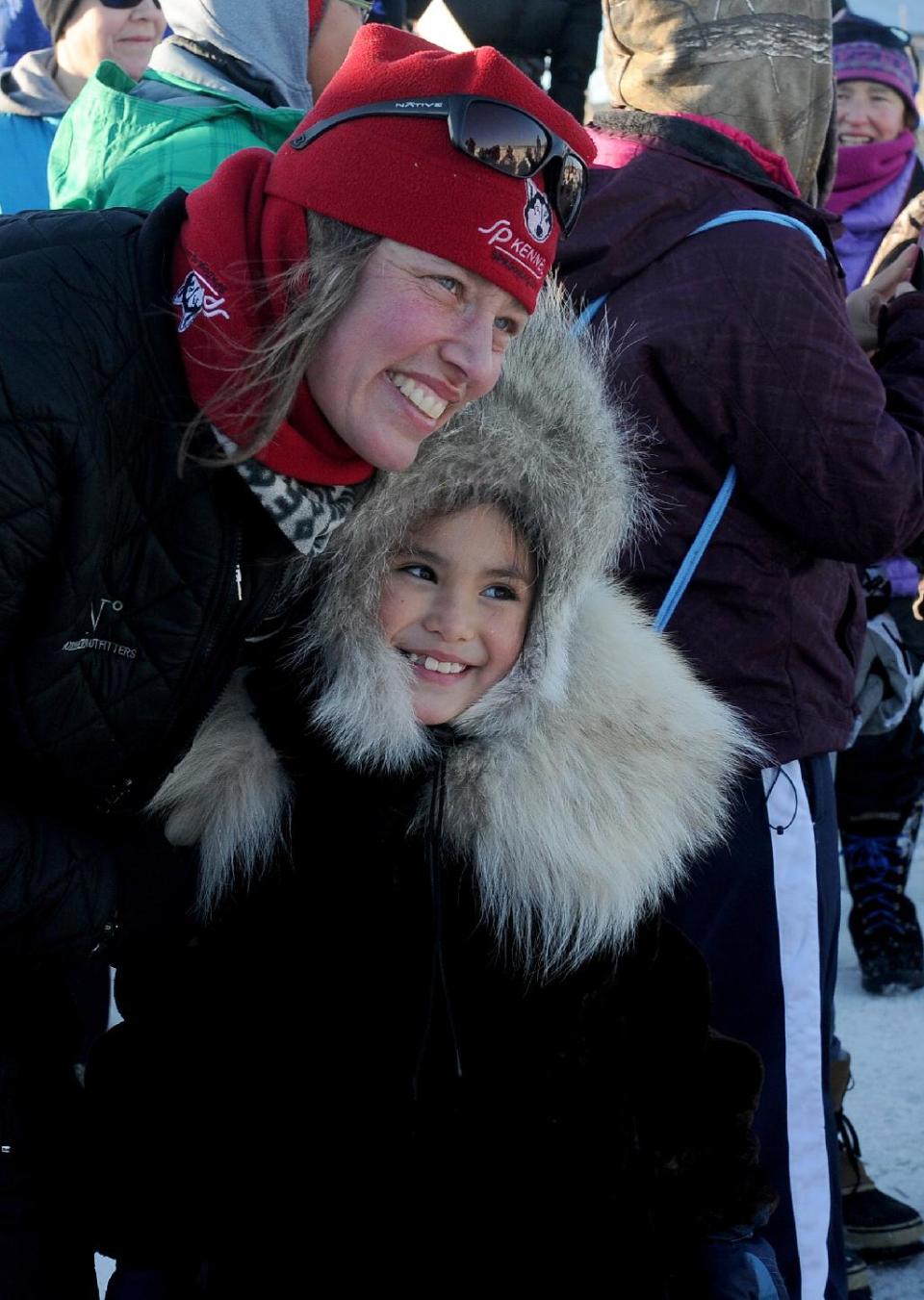 Aliy Zirkle poses for the photo with 8-year-old Autumn Nanouk. Zirkle is the first musher to reach the Bering Sea in Unalakleet during the 2014 Iditarod Trail Sled Dog Race on Saturday, March 8, 2014. Autumn's grandmother, Rhoda Nanouk, made Nanouk's wolf ruff parka. (AP Photo/The Anchorage Daily News, Bob Hallinen)