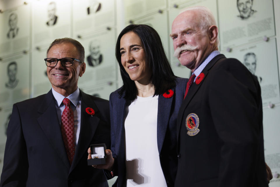 Hockey Hall of Fame 2023 inductee Caroline Ouellette, center, receives his Hockey Hall of Fame ring from Mike Gartner, left, and Lanny McDonald as he's inducted into the Hall in Toronto Friday, Nov. 10, 2023. (Cole Burston/The Canadian Press via AP)