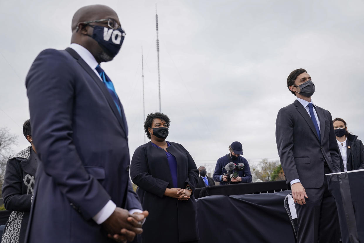 Raphael Warnock, Stacey Abrams and Jon Ossoff listen as U.S. President-elect Joe Biden speaks during a campaign rally. (Photo by Drew Angerer/Getty Images)