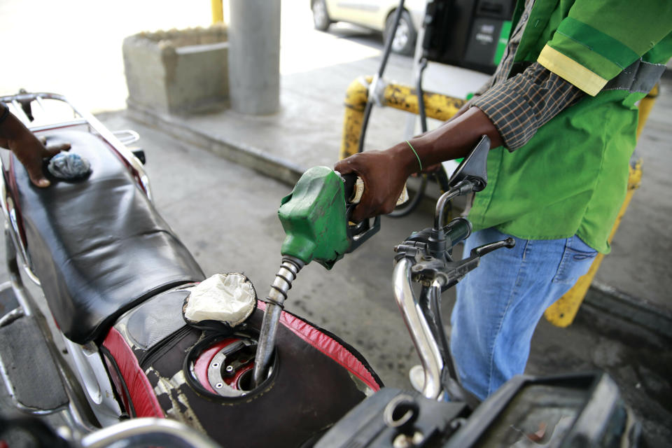 In this April 16, 2019 photo, a gas station attendant fills the gas tank of a motorcycle in Port-au-Prince, Haiti. Through the Venezuelan aid program known as Petrocaribe, more than half the costs of the oil given to Haiti, which came at a heavily discounted price, were repayable over 25 years at a 1% interest rate, allowing the central government to supposedly use the windfall for economic development. (AP Photo/Dieu Nalio Chery)