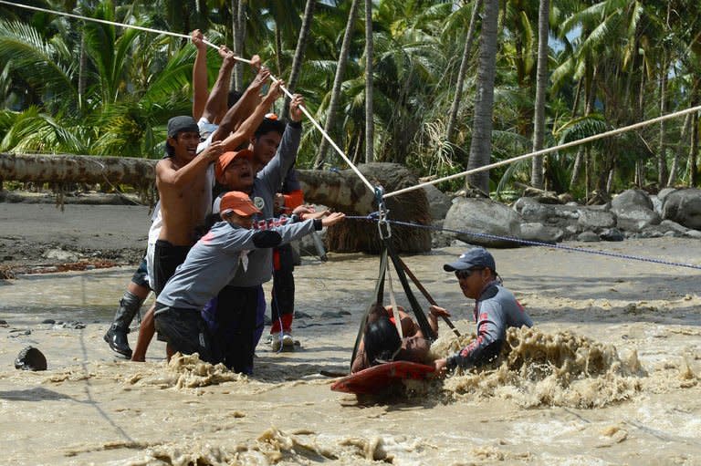 A woman and her child (on stretcher), survivors of Typhoon Bopha, are transported across a surging river in New Bataan town on December 6, 2012. The death toll from the typhoon has risen to 475 with nearly 200,000 left homeless