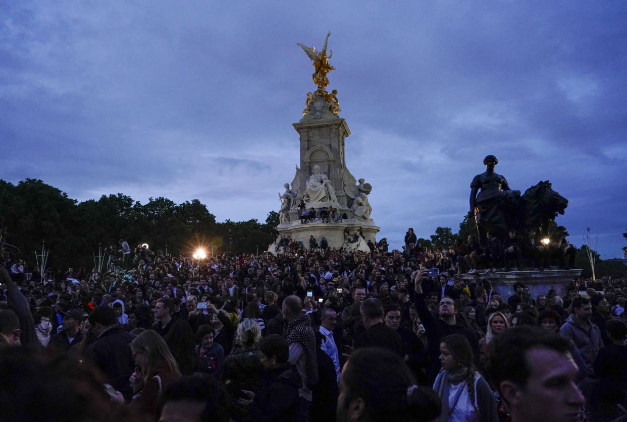 People gather in front of Buckingham Palace, after the announcement of the death of Queen Elizabeth II, in London, Thursday, Sept. 8, 2022. (AP Photo/Alberto Pezzali)