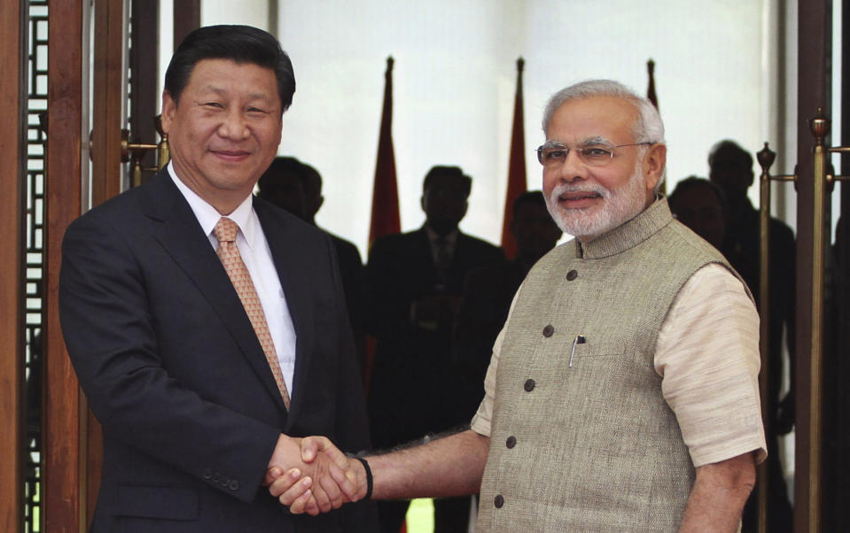 FILE - In this Wednesday, Sept. 17, 2014 file photo, Indian Prime Minister Narendra Modi, right, shakes hand with Chinese President Xi Jinping as he welcomes him at a hotel in Ahmadabad, India. Chinese President Xi Jinping is coming to India to meet with Prime Minister Narendra Modi on Friday, Oct. 11, 2019, just weeks after Beijing supported India's rival Pakistan in raising the issue of New Delhi's recent actions in disputed Kashmir at the U.N. General Assembly meeting. (AP Photo/Ajit Solanki, File)