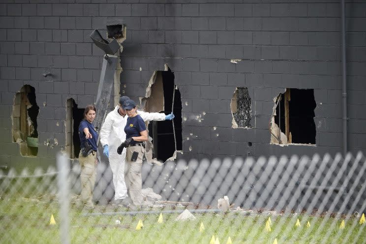 Police officials investigate the back of the Pulse nightclub in Orlando on Tuesday after Sunday's mass shooting. (Phelan M. Ebenhack/AP)