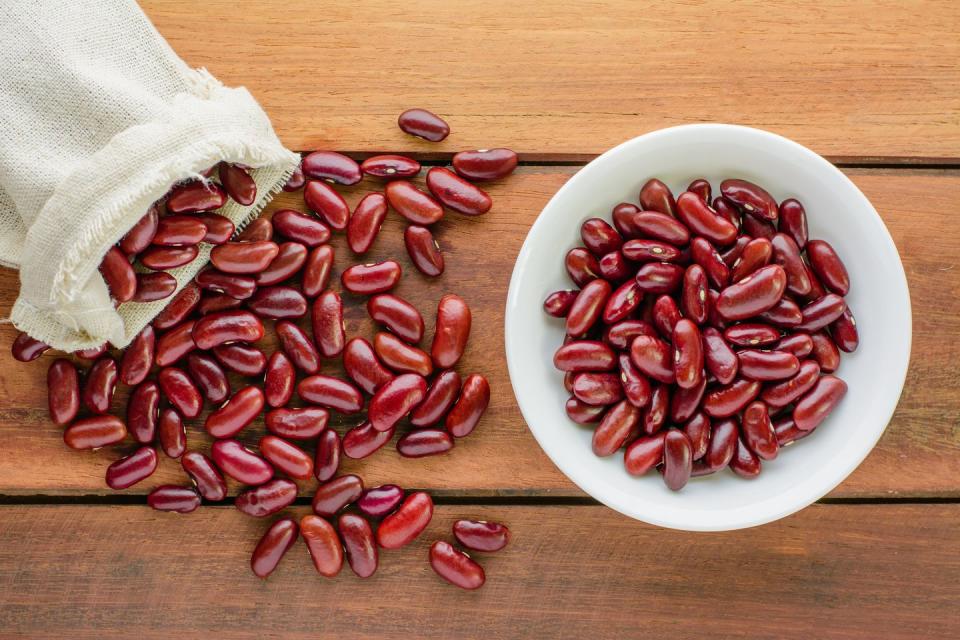 directly above shot of kidney beans with bowl and sack on table