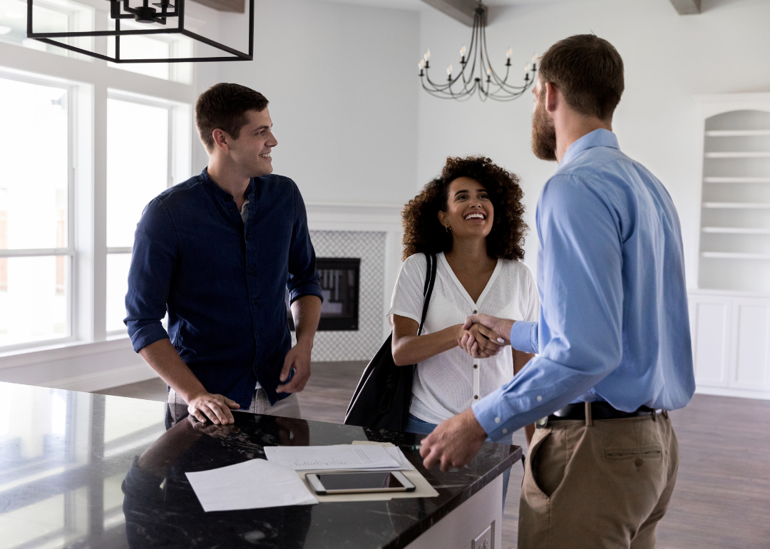 Young couple greeting male realtor.