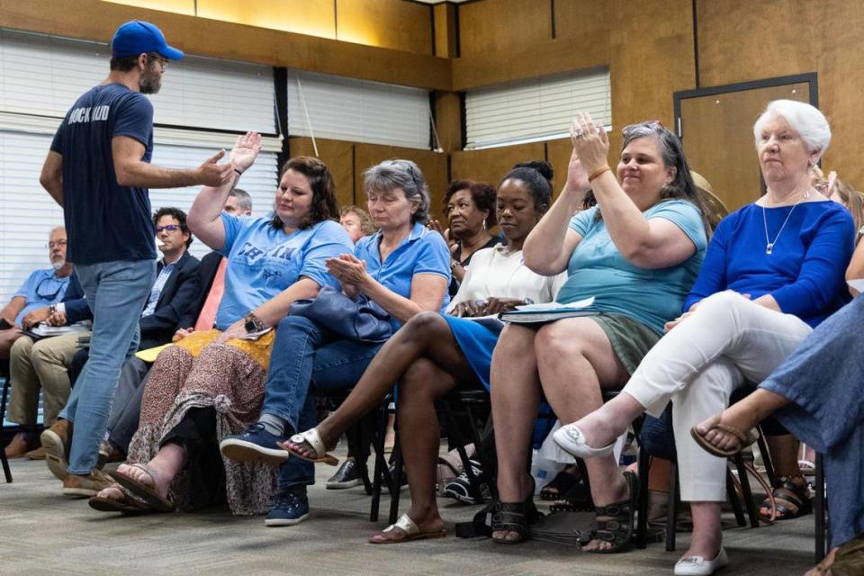 Former teacher Patrick Funk high-fives another supporter of Mary Wood, a teacher at Chapin High School, during a board meeting of the Lexington-Rchland 5 school board on Monday, July 17, 2023. Funk spoke about teaching the Greek tragedy Oedipus Rex, which includes incest and graphic self-harm, and the valuable things students can learn from upsetting material. Joshua Boucher/jboucher@thestate.com