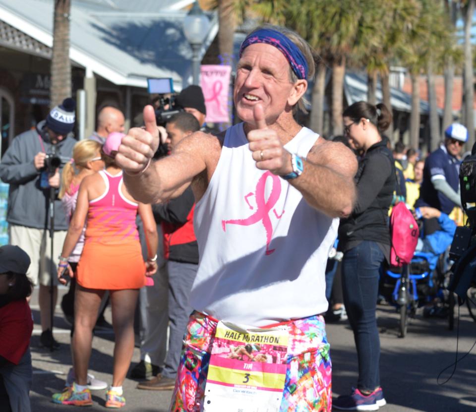 Tim Deegan encourages runners at the finish line of the Donna Marathon in 2020. He ran the half-marathon with wife Donna Deegan, organizer of annual breast cancer fundraiser.