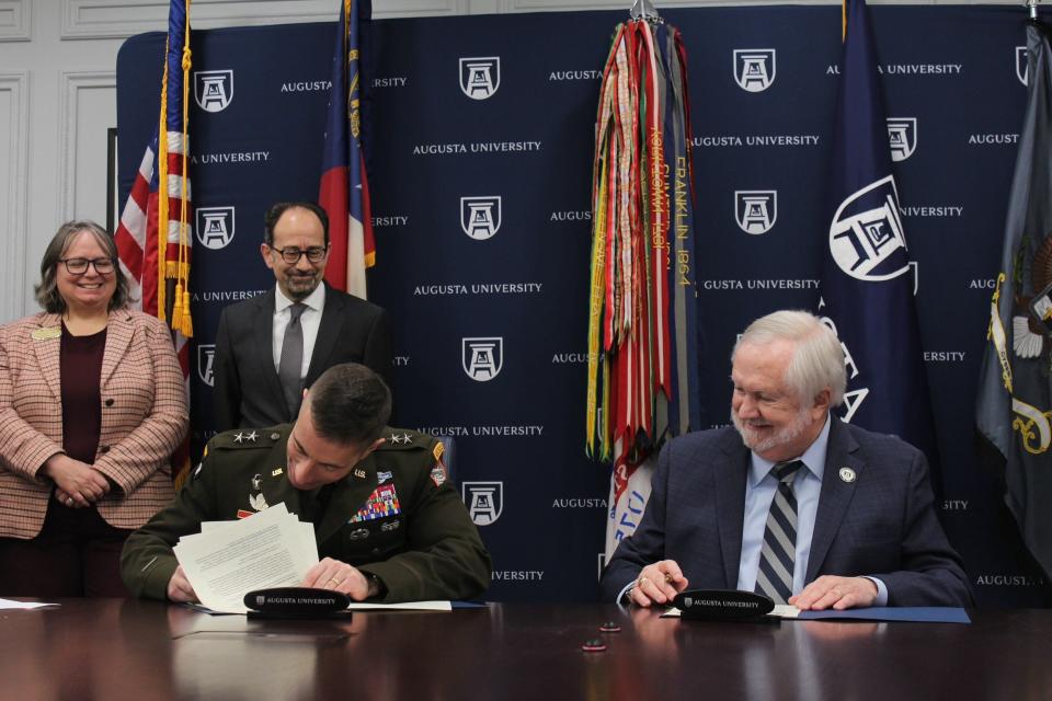 Maj. Gen. Paul T. Stanton, seated, left, and Augusta University President Brooks Keel sign memorandum of understanding on Thursday, Jan. 19. The MOU allows soldiers to receive course credit in the university's new online graduate degrees for military coursework.
