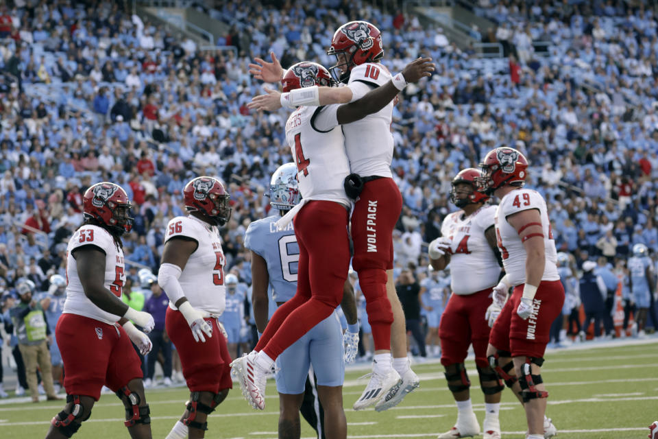North Carolina State quarterback Jack Chambers (14) celebrates his touchdown with quarterback Ben Finley (10) during the first half of an NCAA college football game against North Carolina Friday, Nov. 25, 2022, in Chapel Hill, N.C. (AP Photo/Chris Seward)