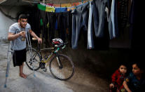 Palestinian cyclist Alaa Al-Daly, 21, who lost his leg by a bullet fired by Israeli troops, stands next to his bicycle at his house in Rafah, southern Gaza Strip, April 18, 2018. REUTERS/Suhaib Salem