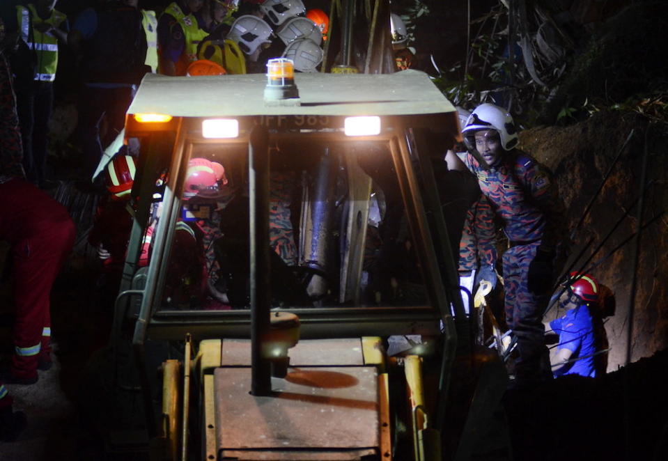 Fire and Rescue Department personnel search for victims of a landslide in Tanjung Bungah, George Town June 25, 2019. — Bernama pic