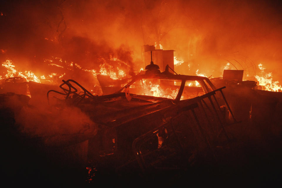 A vehicle burns at a property ravaged from the Fairview Fire Monday, Sept. 5, 2022, near Hemet, Calif. (AP Photo/Ethan Swope)