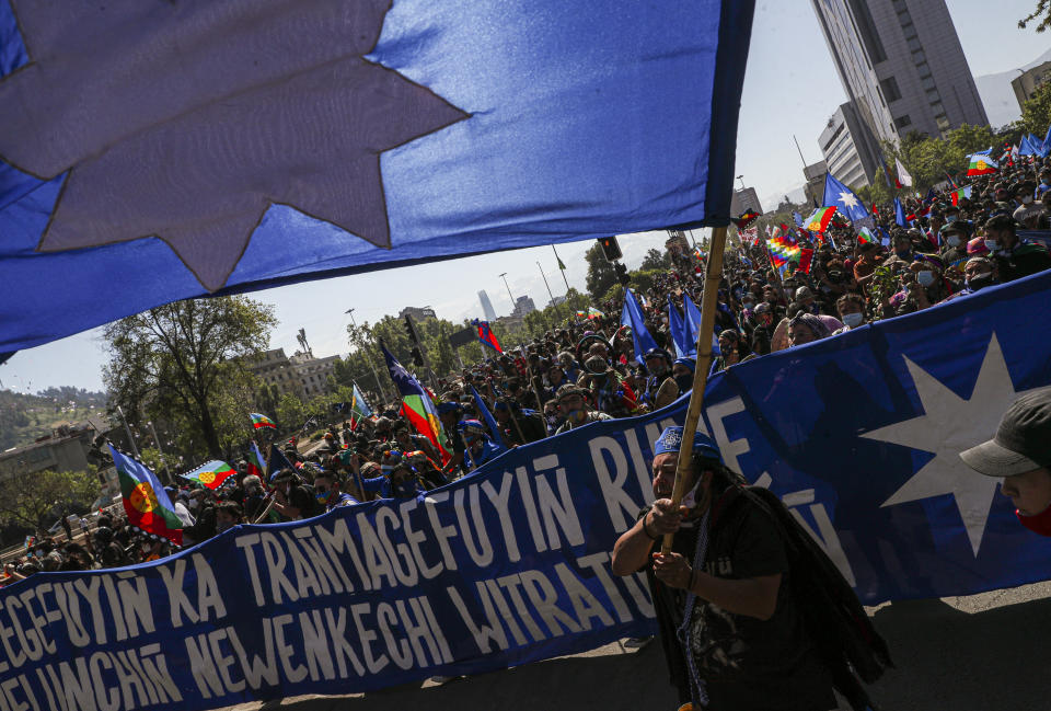 Mapuche Indigenous people march against the discovery of the Americas as they demand autonomy and the recovery of ancestral land in Santiago, Chile, Monday, Oct. 12, 2020. (AP Photo/Esteban Felix)