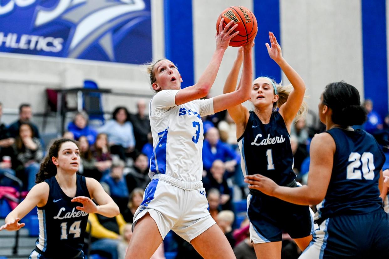Lansing Community College's Kara Bartels, left, grabs a rebound over Mid Michigan College's Leah Helsel during the first half on Tuesday, Dec. 19, 2023, in Lansing.