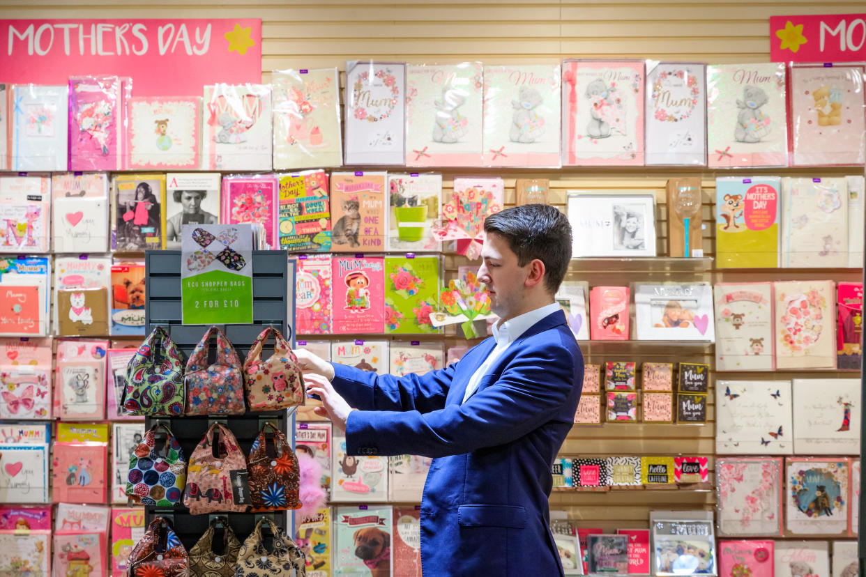 Paperchase  London, UK - March 26, 2017 - A male customer browsing Mother’s Day cards in a stationery store in Canary Wharf with a shelf of Mother’s Day cards in 