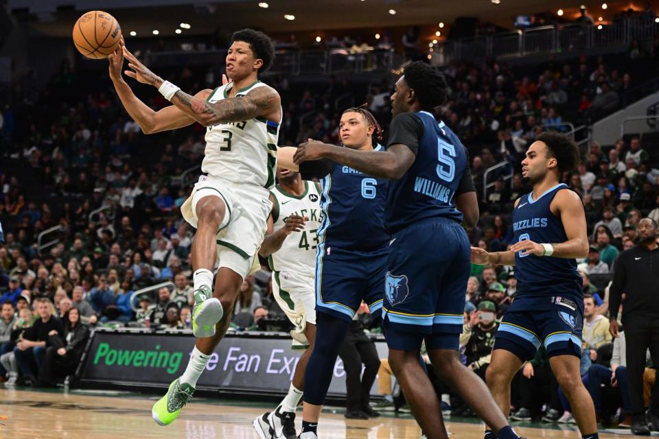 Bucks forward MarJon Beauchamp passes in front of Memphis Grizzlies forward Kenneth Lofton Jr. (6) and center Vince Williams Jr. in the fourth quarter of the teams' final preseason game Friday night at Fiserv Forum.