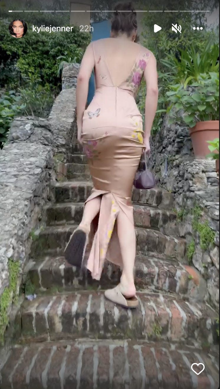 A screenshot of Kendall Jenner awkwardly walking up a set of brick steps